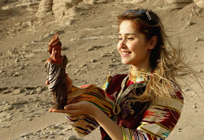 2 絲綢古道新疆姑娘萊孜乃在羅布泊捧著關帝木雕像（朱正明攝影）.jpg