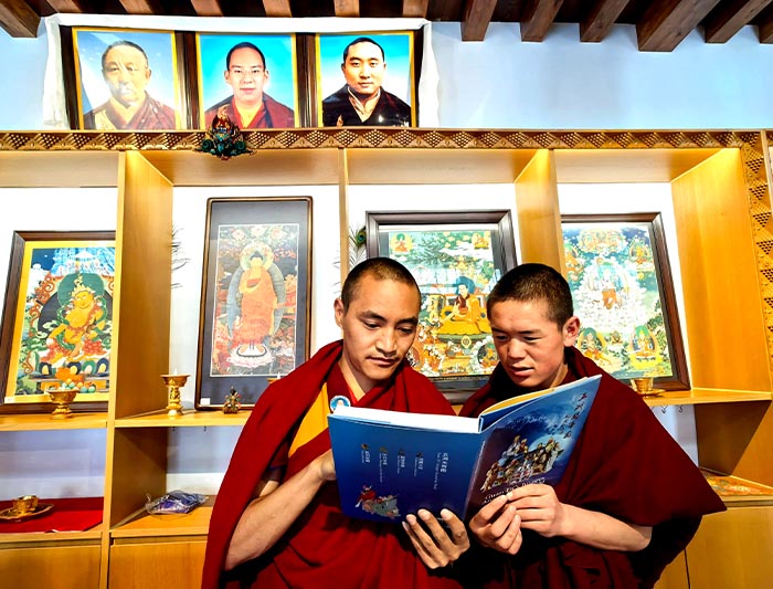 15 在日喀則扎什倫佈寺，強巴丹增喇嘛（左）正在讀新書《五洲關帝圖》（朱正明攝影）.jpg